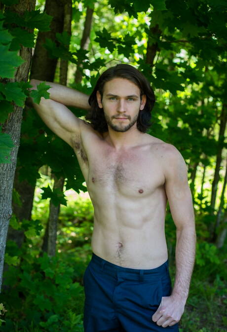 Der haarige amerikanische Hengst Duncan Black spielt im Freien mit seinem Schwanz