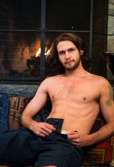 Der haarige amerikanische Hengst Duncan Black spielt im Freien mit seinem Schwanz