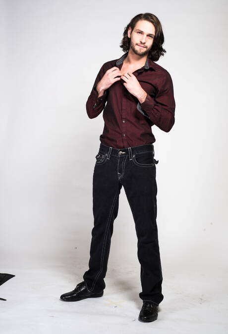 Der haarige amerikanische Hengst Duncan Black spielt im Freien mit seinem Schwanz