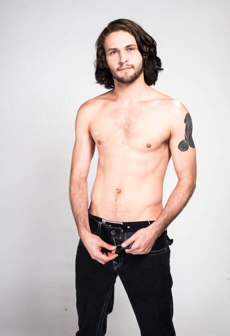 Der haarige amerikanische Hengst Duncan Black spielt im Freien mit seinem Schwanz