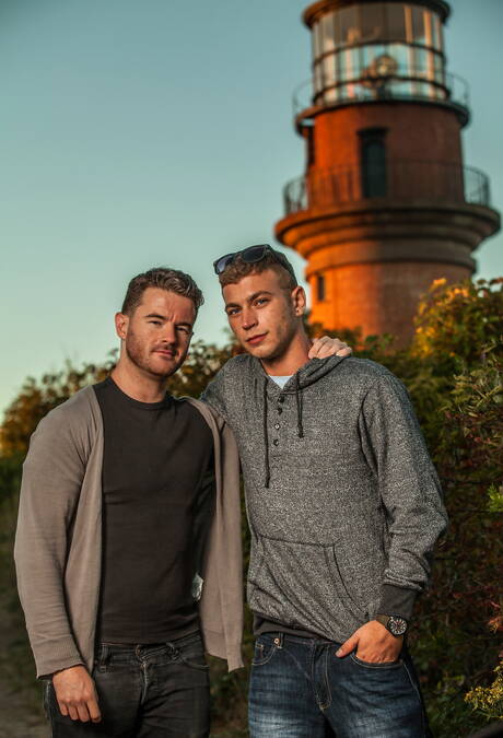 Amerikaanse otter Alexander Greene en Ierse harige beer Brendan Patrick poseren naakt op het strand
