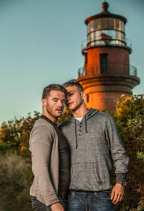 Amerikaanse otter Alexander Greene en Ierse harige beer Brendan Patrick poseren naakt op het strand