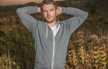 Amerikaanse otter Alexander Greene en Ierse harige beer Brendan Patrick poseren naakt op het strand