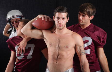 Sporty gays Aiden, Alexander and Brandon posing in football uniform