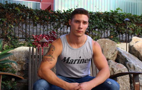 Der amerikanische Kraftprotz Spencer Laval spielt im Freien mit seinem Schwanz