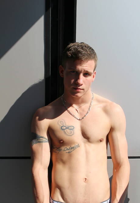 Hengst Mike Hollister zeigt im Freien einen Muskelkörper