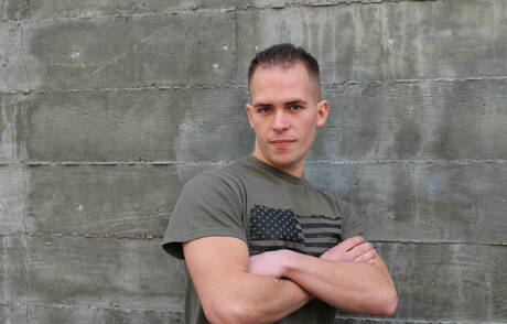 O musculoso americano Richard Buldger brincando com um pau do lado de fora