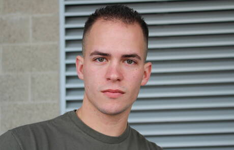 O musculoso americano Richard Buldger brincando com um pau do lado de fora