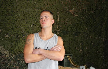 O musculoso americano Richard Buldger brincando com um pau do lado de fora