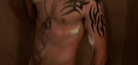 Il muscoloso Kenny gioca con il cazzo sotto la doccia calda