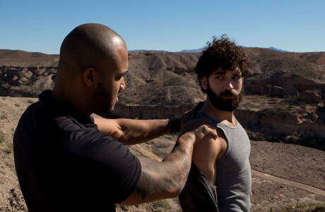 Der amerikanische Otter Tegan Zayne und der schwarze Kraftprotz Jason Vario in einer Schwanzlutschszene im Freien