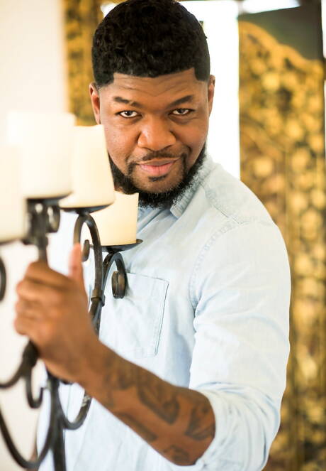 Black muscular Mr. Cali shows a husky body outdoor