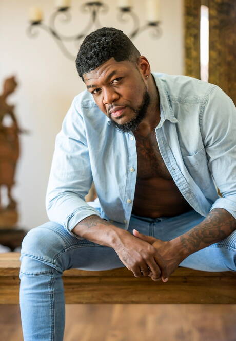 Black muscular Mr. Cali shows a husky body outdoor