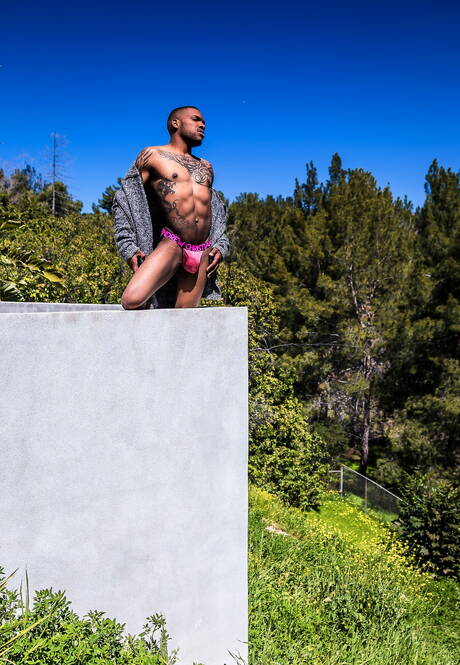 Black muscular Aaron Reese shows a husky body outdoor