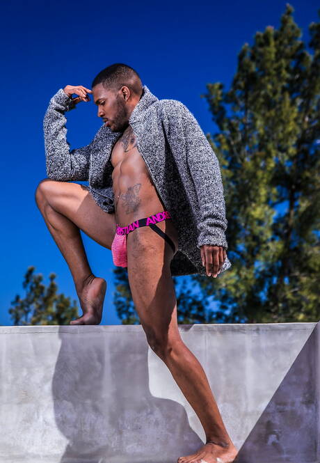Noir Male: Black muscular Aaron Reese shows a husky body outdoor
