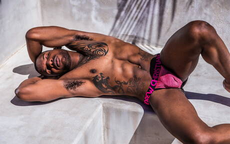 Black muscular Aaron Reese shows a husky body outdoor