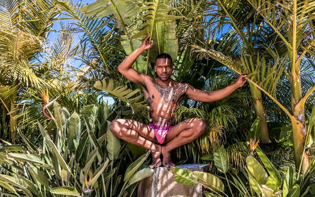 De gespierde zwarte Aaron Reese toont een gespierd lichaam in de buitenlucht