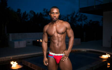 De goed gebouwde ebbenhouten Deangelo Jackson toont een sterk lichaam bij het zwembad