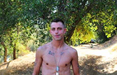 El joven Tanner Reed posando desnudo al aire libre