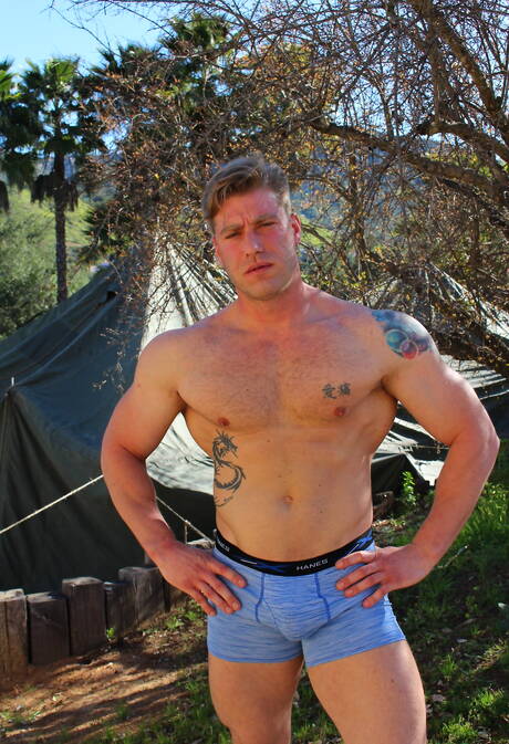 Sterke stier John Hawkins toont een gespierd lichaam aan de buitenkant