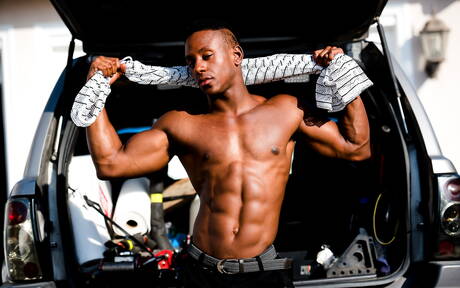 El hombre fuerte de ébano Liam Cyber muestra un cuerpo robusto al aire libre