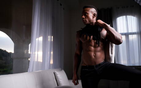 El hombre fuerte de ébano Liam Cyber muestra un cuerpo robusto al aire libre