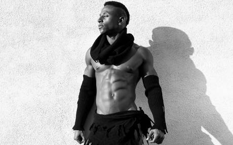 El hombre fuerte de ébano Liam Cyber muestra un cuerpo robusto al aire libre