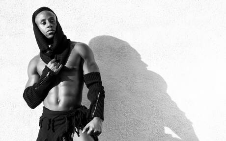 El hombre fuerte de ébano Liam Cyber muestra un cuerpo robusto al aire libre