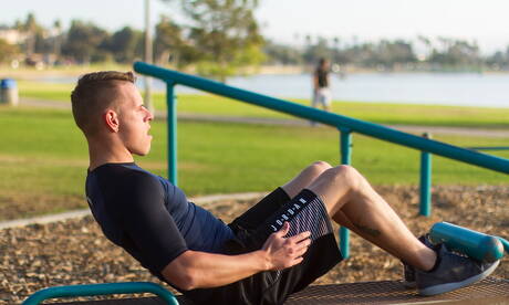 Der amerikanische Bodybuilder Shane Cook posiert nackt draußen