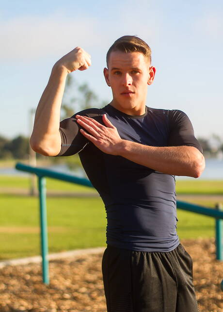 Der amerikanische Bodybuilder Shane Cook posiert nackt draußen