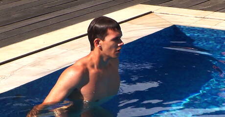 Tsjechische gespierde Jason Clark speelt met zijn pik bij het zwembad