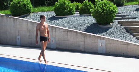 Tsjechische gespierde Jason Clark speelt met zijn pik bij het zwembad