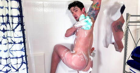 Der kräftige Amerikaner Dakota Payne spielt unter der Dusche mit einem Dildo