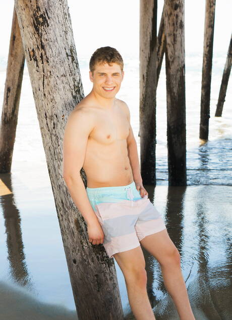 Well-built Kieran undressing and showing tight butt on beach