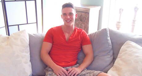 Gutaussehender junger Junge spielt mit seinem großen Schwanz und zeigt sein Sperma