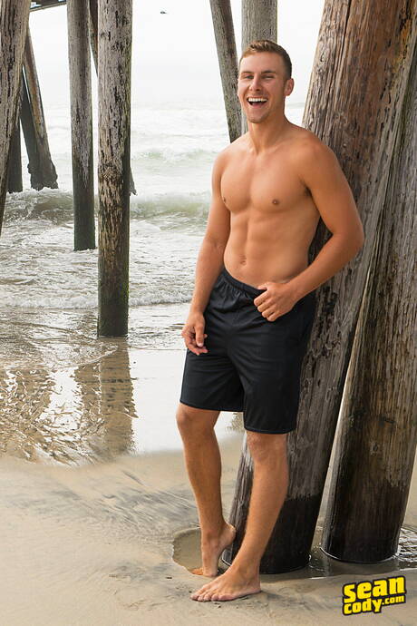 ハンサムな男スミスがビーチの後で裸のポーズをとり、セクシーなお尻を見せる