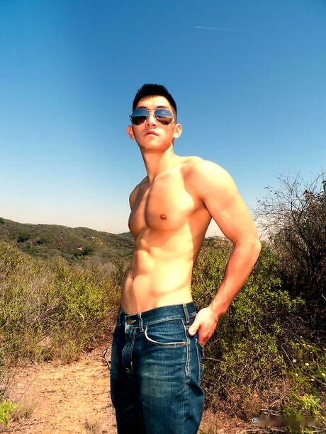 Oriental strong bull Eric East posing nude and showing tight ass outside