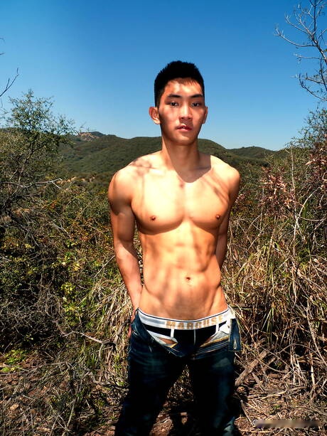 Oriental strong bull Eric East posing nude and showing tight ass outside