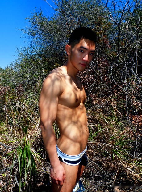 Oriental strong bull Eric East posing nude and showing tight ass outside