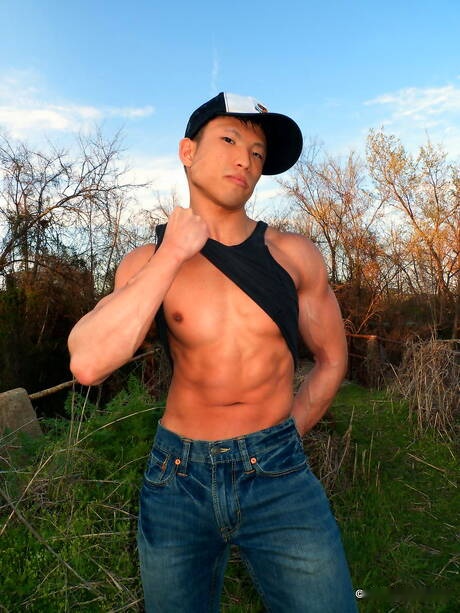 Oriental bodybuilder Jessie Lee undressing and showing tight butt outside