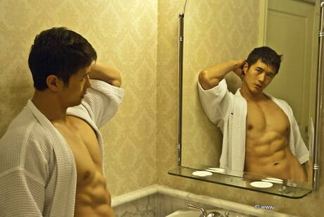 Il muscoloso orientale Peter Le posa nudo e mostra un bel sedere in bagno