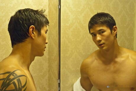 Il muscoloso orientale Peter Le posa nudo e mostra un bel sedere in bagno