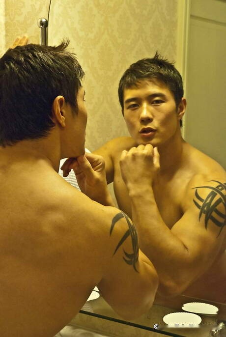 Il muscoloso orientale Peter Le posa nudo e mostra un bel sedere in bagno