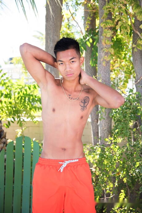 Oriental twink Alec Cruz posing nude and showing tight butt outdoor