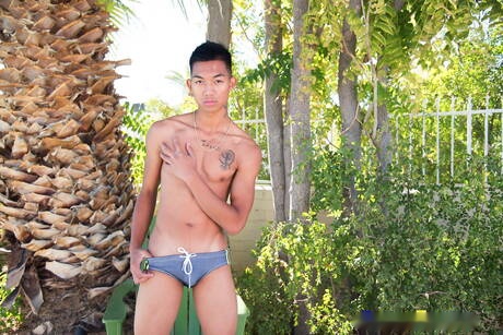 Oriental twink Alec Cruz posing nude and showing tight butt outdoor