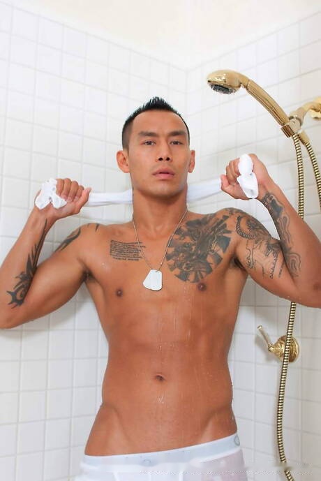 Keni Styles, un homme asiatique musclé, se déshabille et montre ses fesses sous la douche.