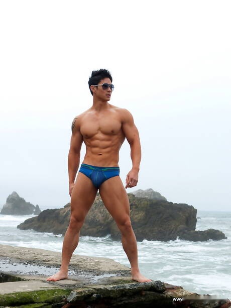 El toro oriental fuerte Peter Le muestra un cuerpo musculoso después de caminar por la playa