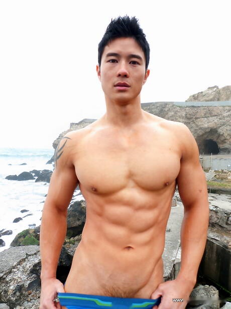 El toro oriental fuerte Peter Le muestra un cuerpo musculoso después de caminar por la playa