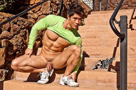 Oriental strong bull Peter Le in white boots take off his clothes outdoor