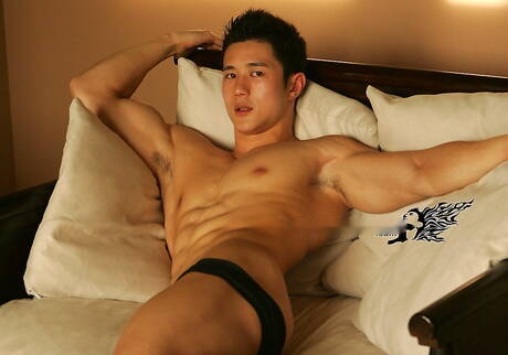Aziatische gespierde Peter Le toont een stevig lichaam op de bank